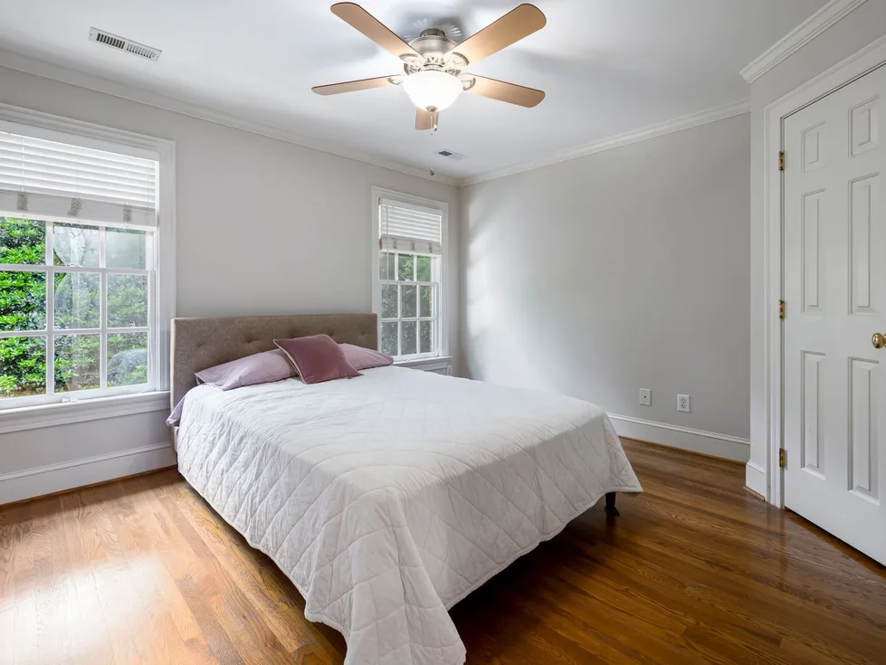 A bright bedroom with a freshly made white bed