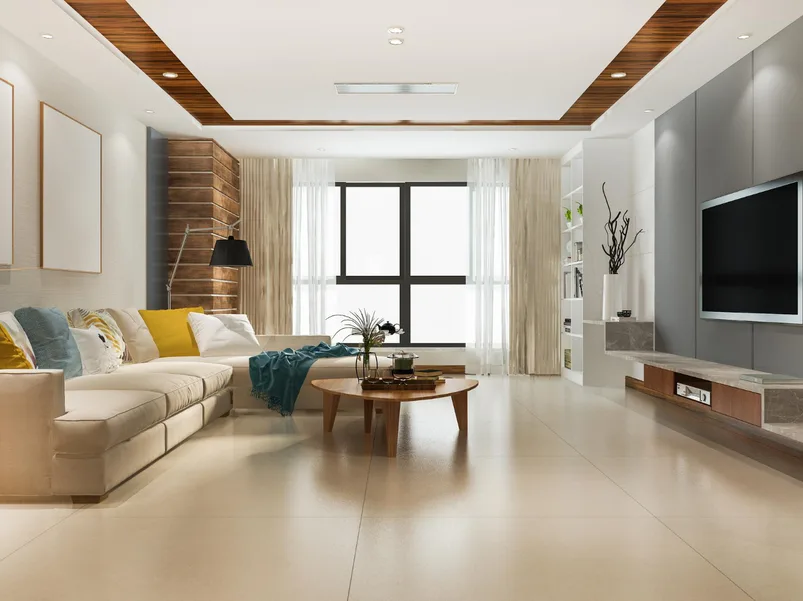 A staged living room with a stone fireplace and double-height windows