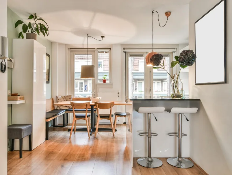 A tidy modern office with wooden desks and a tall plant