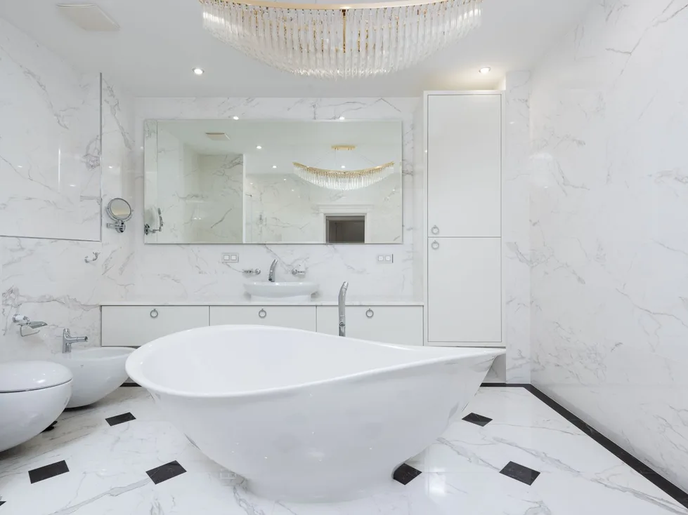 A white marble bathroom with a freestanding tub